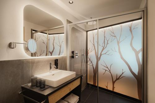 a bathroom with a sink and a shower at Hotel La Müda in Badia
