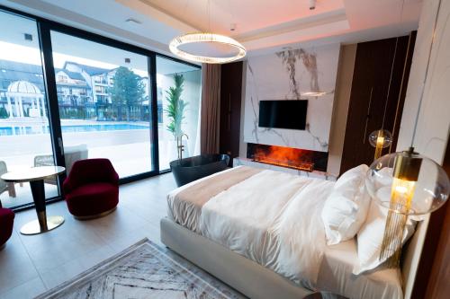 a bedroom with a large bed with a fireplace at Verde by Hotel Gabriela in Vişeu de Sus