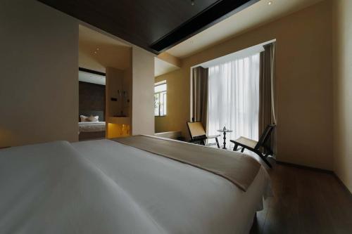 a large white bed in a room with a window at Good Night Hotel in Zhangjiajie