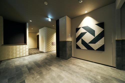 a room with a television and a painting on the wall at Rakuten STAY Kokura Station Standard Triple Room in Kitakyushu