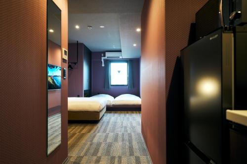 a hotel room with two beds and a door with a corridor at Rakuten STAY Kokura Station Standard Double Room in Kitakyushu
