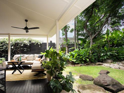 a patio with a couch and a table and some plants at Garden Oasis-2br -1 min from the beach & pet friendly! in Suffolk Park