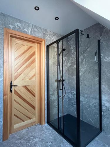 a shower with a wooden door in a room at Chata u Przewodnika in Ostrowsko