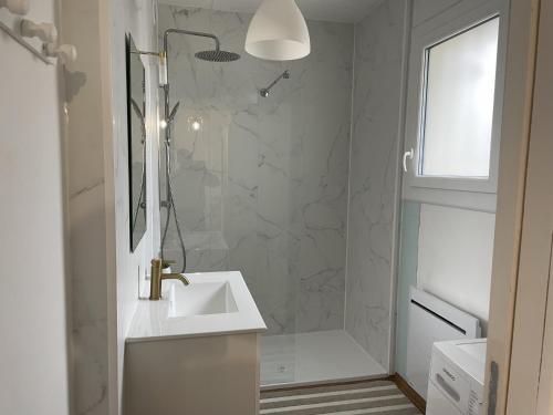 a white bathroom with a sink and a shower at Les Fortelles in Châtillon-sur-Broué