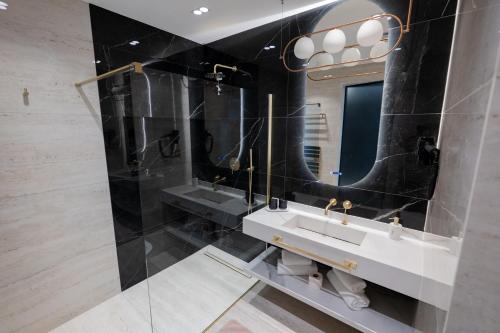 a bathroom with two sinks and a mirror at Verde by Hotel Gabriela in Vişeu de Sus