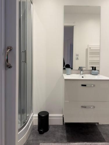 a white bathroom with a sink and a shower at large downtown studio in Corbeil-Essonnes