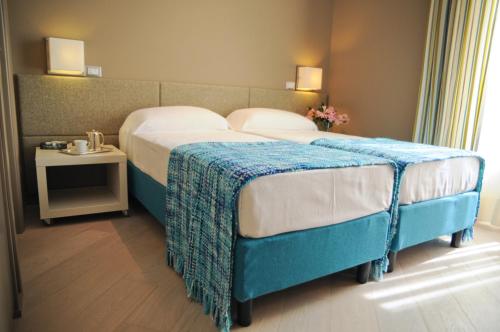 ローマにあるB&B Carini 58のベッドルーム1室(青い毛布付きのベッド1台付)