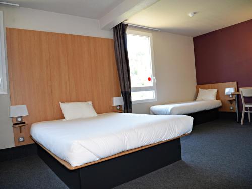 Saint-Martin-de-ValgalguesにあるB&B HOTEL Alès - Pôle Mécaniqueのベッド2台と窓が備わるホテルルームです。