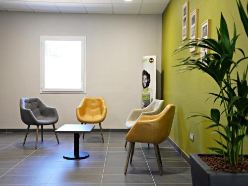 a waiting room with chairs and a potted plant at B&B HOTEL Alès - Pôle Mécanique in Saint-Martin-de-Valgalgues