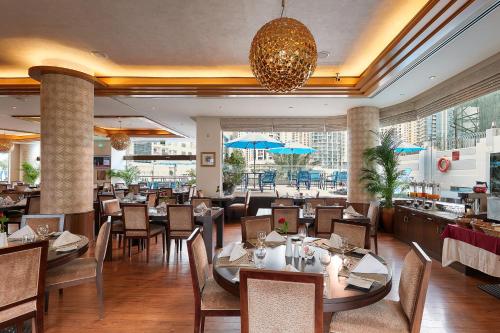 a dining room with tables and chairs and a restaurant at City Premiere Marina Hotel Apartments in Dubai