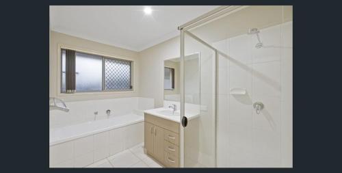 a bathroom with a tub and a sink and a shower at 4 bedrooms with queen sized bed each room in Riverview