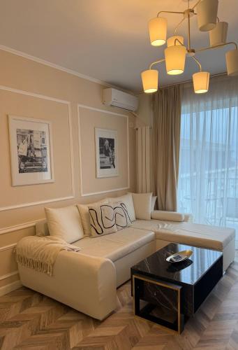 a living room with a couch and a table at GLIM SUITE in Oradea