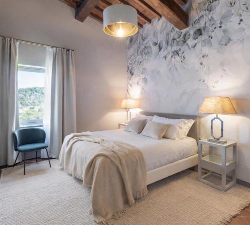 a bedroom with a large bed and a chair at Borgo Iesolana Country Retreat in Bucine