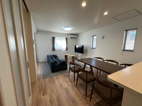a room with a table and chairs and a couch at 熊讚Bear Best House in Kumamoto