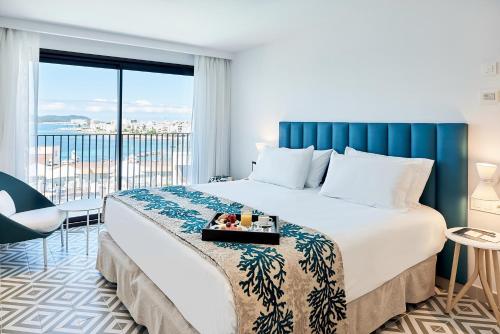 a hotel room with a large bed and a large window at Eurostars Ibiza in Ibiza Town