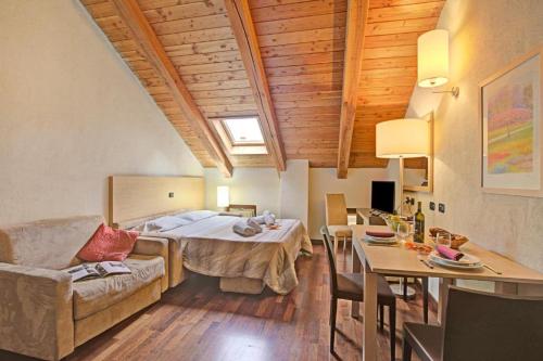 a bedroom with a bed and a living room with a table at Residence Cianfuran in Bardonecchia