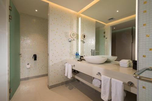 a bathroom with two sinks and a large mirror at Hotel Las Americas Golden Tower Panamá in Panama City