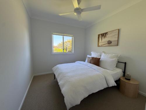 a bedroom with a bed and a ceiling fan at Family Holiday Home Ulladulla in Ulladulla
