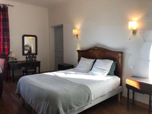 a bedroom with a bed and a desk and a mirror at Ancien hôtel aux moines Pierrefitte St Lo in Saint Lo