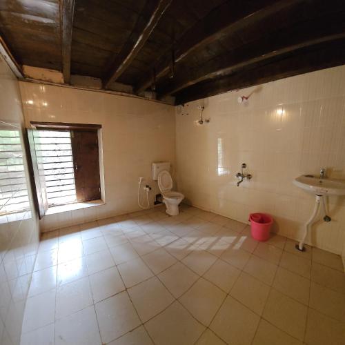 a bathroom with a toilet and a sink at Taramrata Homestay in Gokarna