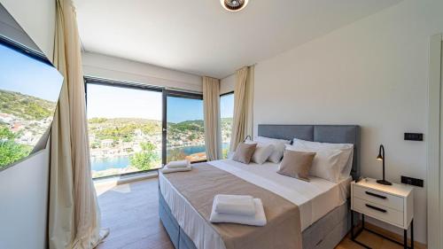 a bedroom with a large bed with a large window at Villa Lana by Villas Guide in Vela Luka