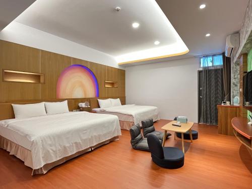 a hotel room with two beds and a rainbow on the wall at Wind Sea Hill Inn in Hengchun South Gate