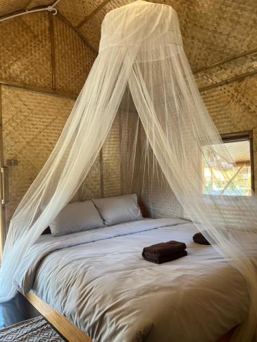 a bed with a net canopy in a room at Mook Mellow Hill Bungalows in Ko Mook