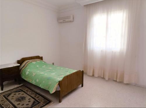 a bedroom with a bed and a window at Sunshine Villa in Gabès