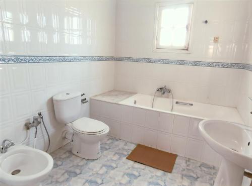 a bathroom with a toilet and a tub and a sink at Sunshine Villa in Gabès