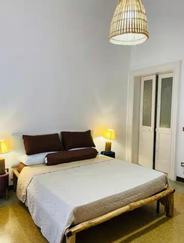 a bedroom with a large bed and a chandelier at Dongiovanni Suite in Lecce
