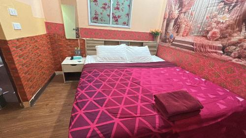 a bedroom with a bed with a pink comforter at Asia Mahanakhorn Travel in Bangkok