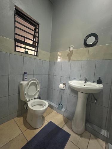 a bathroom with a toilet and a sink at Entire rental unit in Pretoria