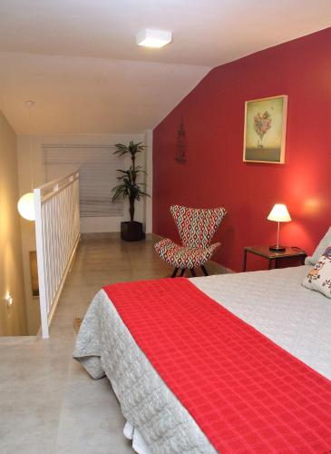 a bedroom with a bed and a red wall at Pousada Casa das Flores in Sao Jorge
