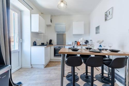 une cuisine avec une table en bois et des tabourets noirs dans l'établissement Le Nautique, à Valence