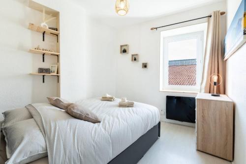 une chambre blanche avec un lit et une fenêtre dans l'établissement Le Nautique, à Valence