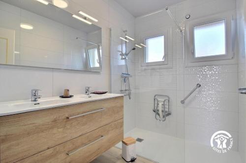 a white bathroom with a shower and a sink at Le clos du bas in Noyal-Muzillac
