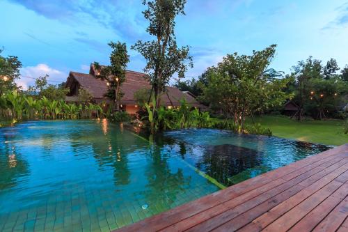 a swimming pool in front of a house at Azalea Village in Chiang Dao