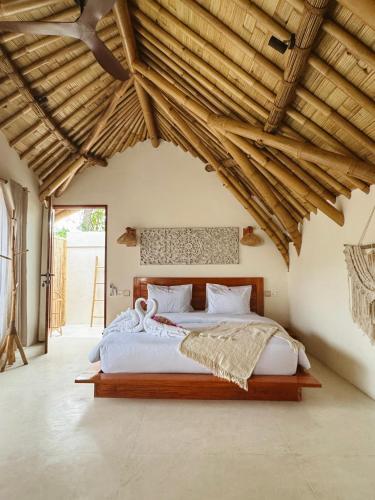 a bedroom with a large bed with a wooden ceiling at Sea Turtle Villas in Gili Islands