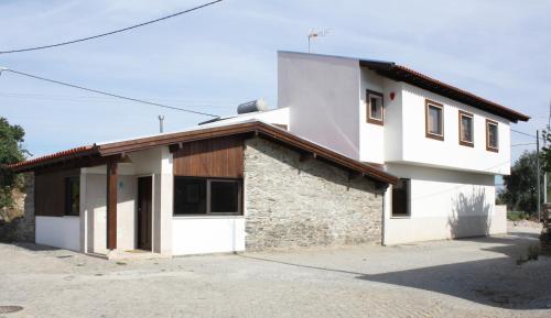 a white house with a brown roof at Casa do Ferrador in Mirandela