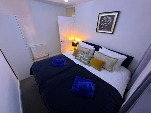 a bedroom with a large bed with blue pillows at Victoria Maidstone Tranquil Retreat in Maidstone