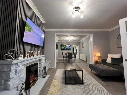 a living room with a fireplace and a tv at Victoria Maidstone Tranquil Retreat in Maidstone