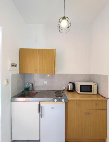 a kitchen with a sink and a microwave at Panagiotis Studios in Laganas