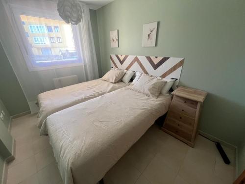 a bedroom with two beds and a night stand at Apartamento Senda in Comillas