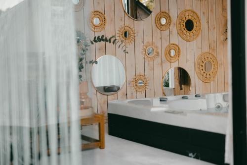 ein Badezimmer mit Waschbecken und Spiegeln an einer Holzwand in der Unterkunft Essential by cin in Zonhoven