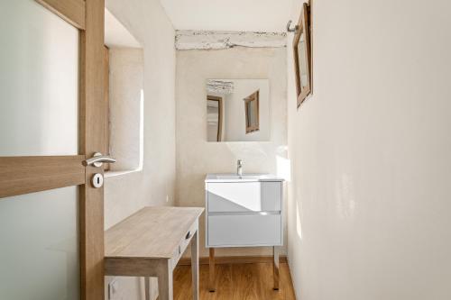a small bathroom with a sink and a table at Le Cocon de la Combe - Maisonnette pour 4p in Coursegoules