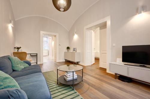 a living room with a blue couch and a tv at Deluxe Apartment Talia by Irundo in Zagreb