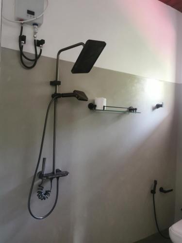 a bathroom with a shower head on a wall at Villa Rina in Kottagoda