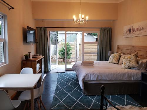 a bedroom with a large bed and a table and chairs at Coach House Bed and Breakfast in Greytown