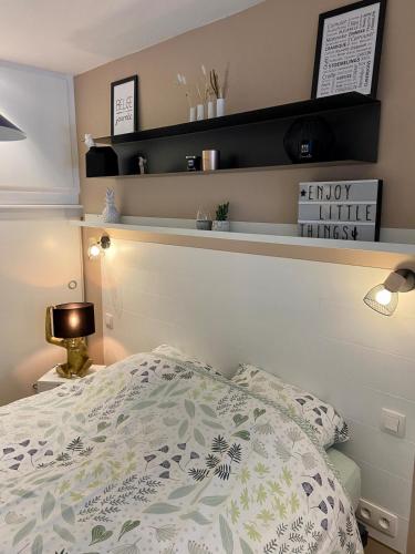 a bedroom with a bed and a shelf above it at Studio face au château de Thy in Thy-le-Château