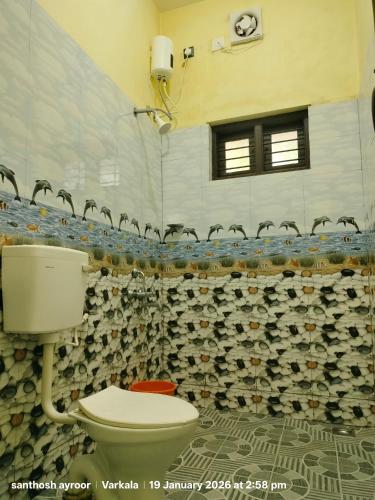 a bathroom with a toilet and a shower at isha homestay in Varkala